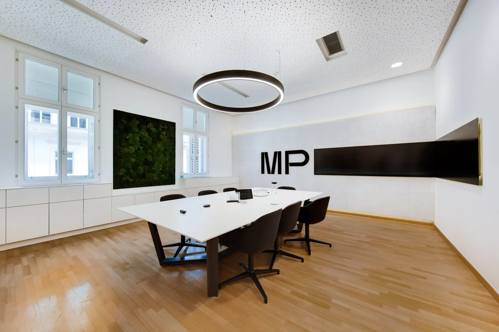 Conference room with white table and logo on the wall
