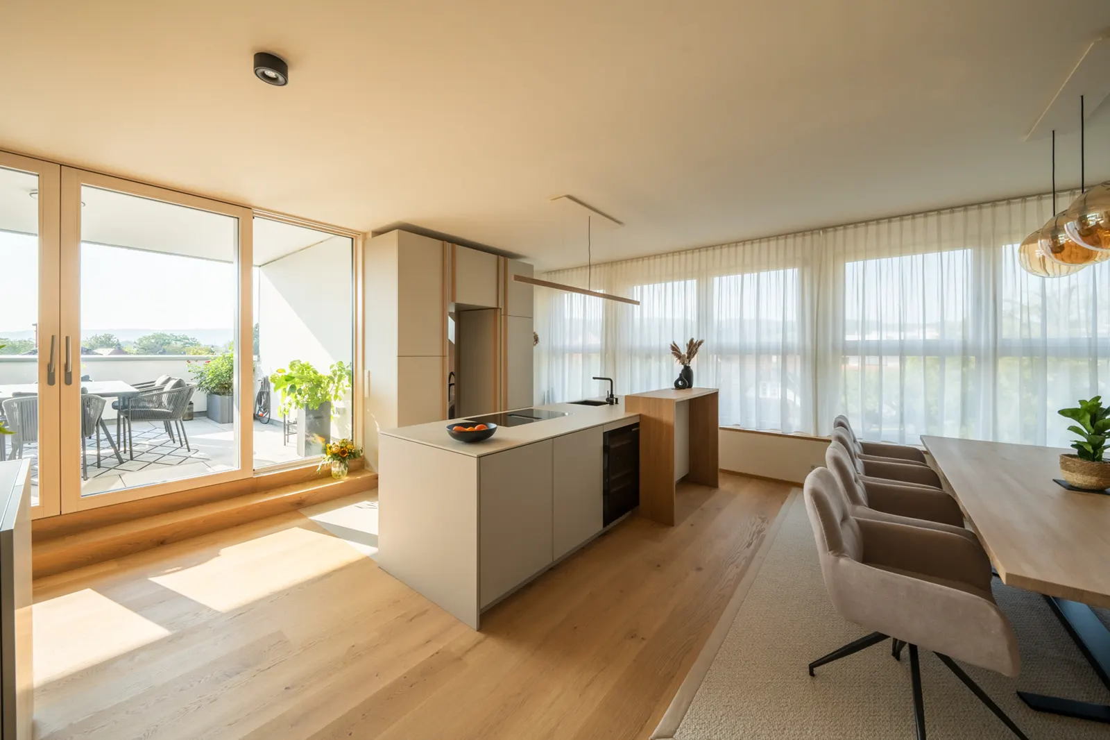 Bright open-plan kitchen with dining table and wall of windows, property video for BergnerDesign