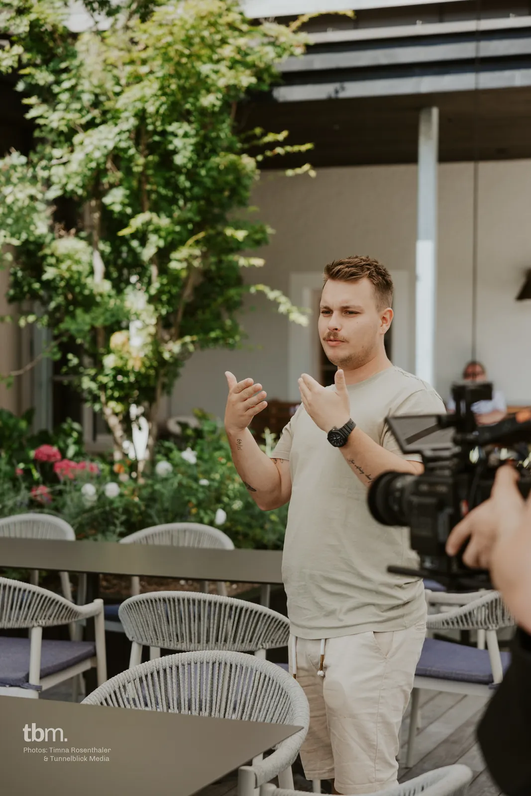 Dennis explaining a scene with his hands, a camera in the foreground