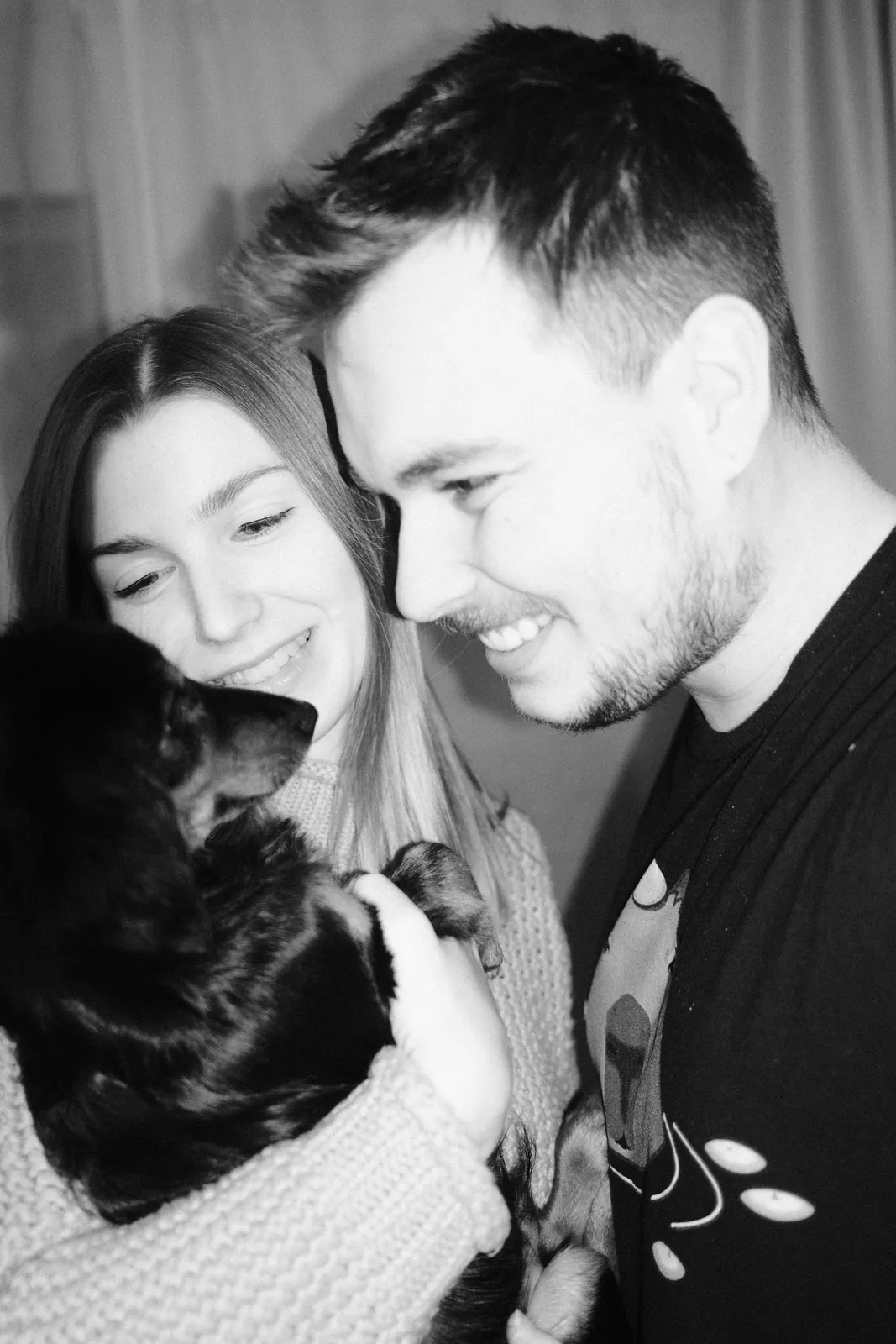 Dennis laughing with his partner and Pentu, black and white
