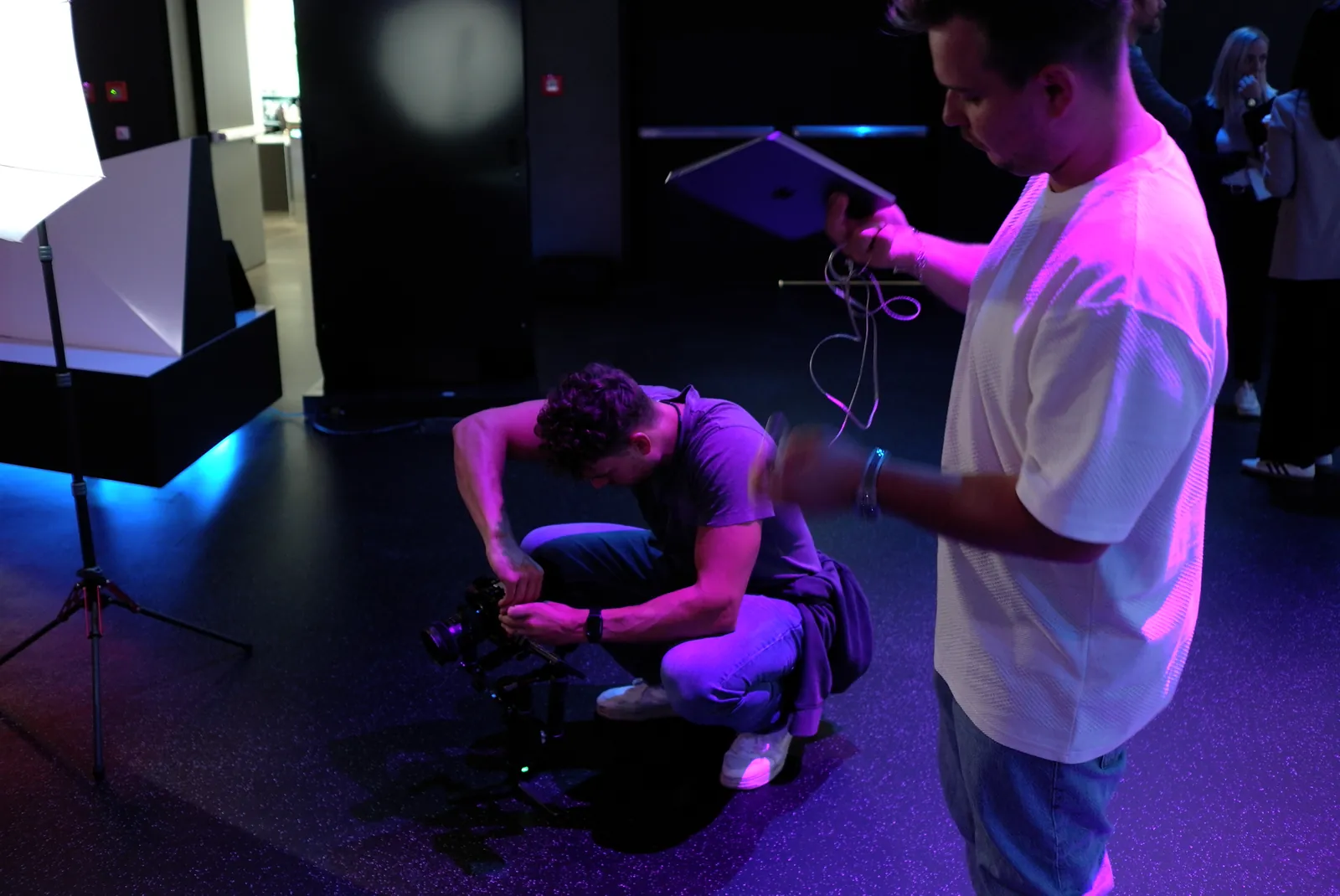 Dennis on set in violet light with a tablet in his hand