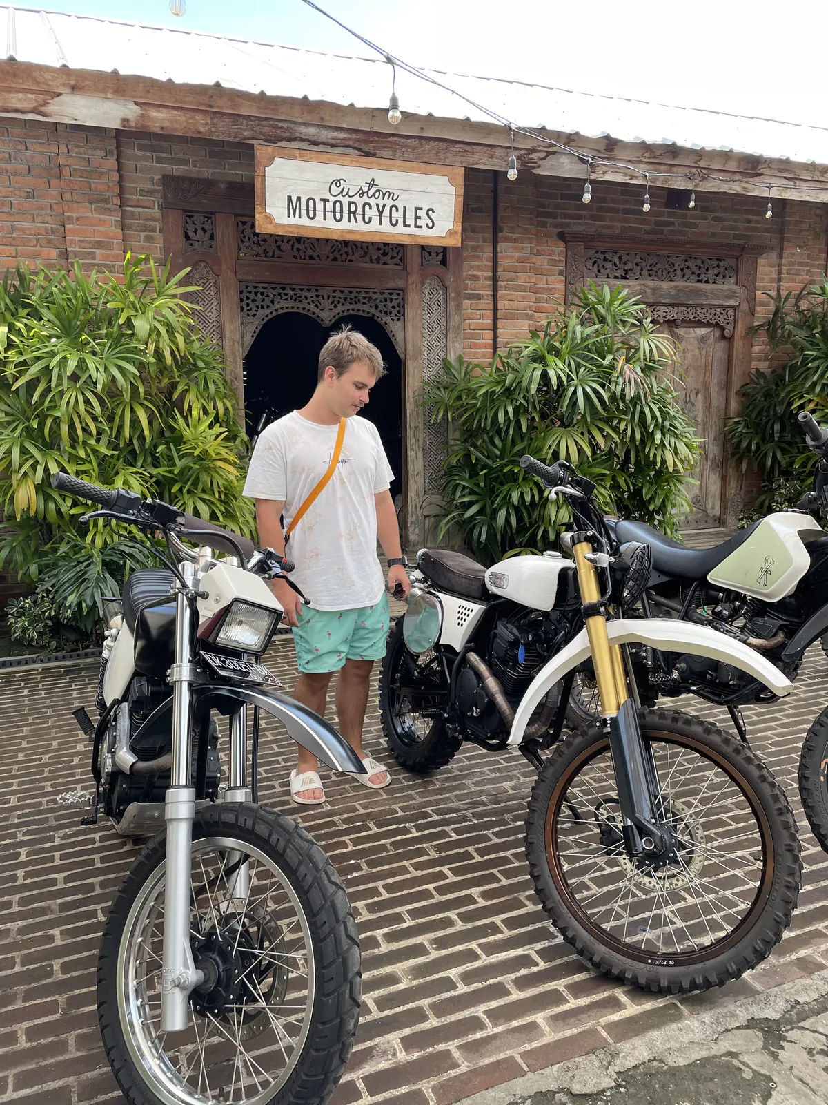 Dennis in front of a custom motorcycle workshop